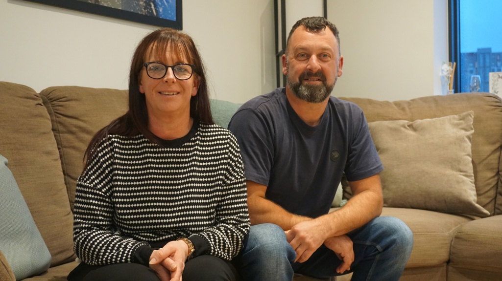 Yorkshire Housing customers Liz and Paul sat on the sofa at their new home at the Climate Innovation District in Leeds.