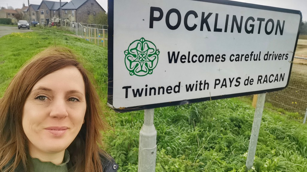 Leanne taking a selfie by the Pocklington town sign saying it pairs with Pays de Racan 