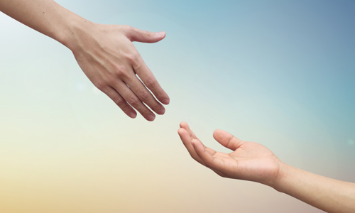 Two hands reaching towards each other like they want to hold hands. Yellow and blue background. 