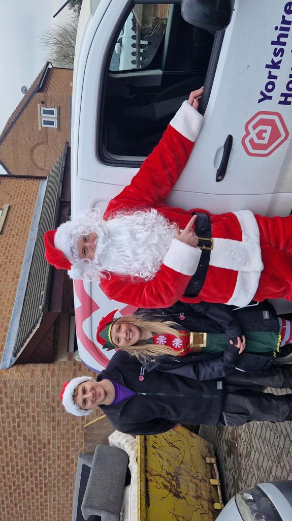 Colleagues standing in front of a Yorkshire Housing van dressed as Santa and a Christmas elf