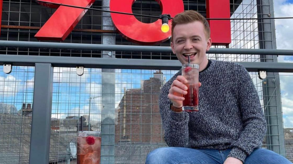 Liam Owenson having a drink at an outdoors venue