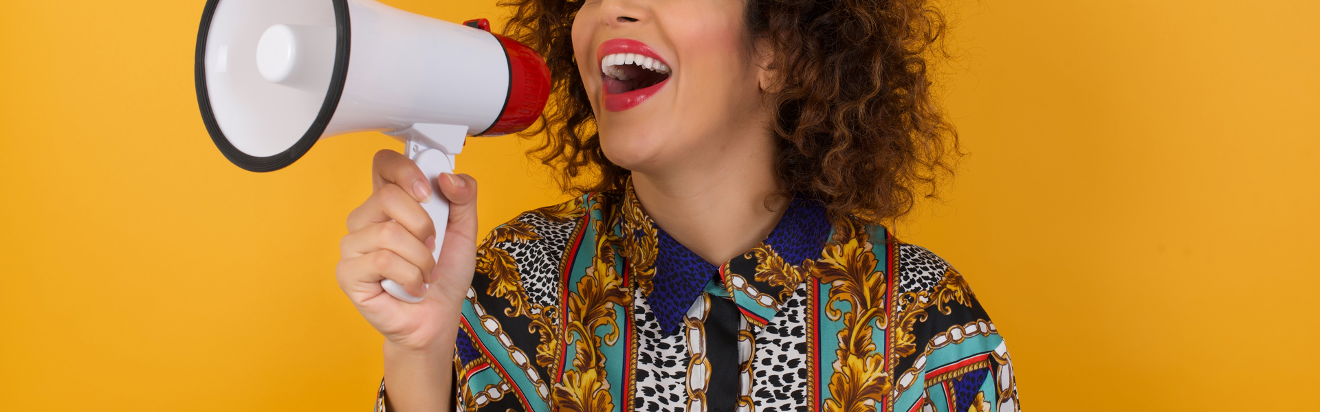 Young happy woman using megaphone